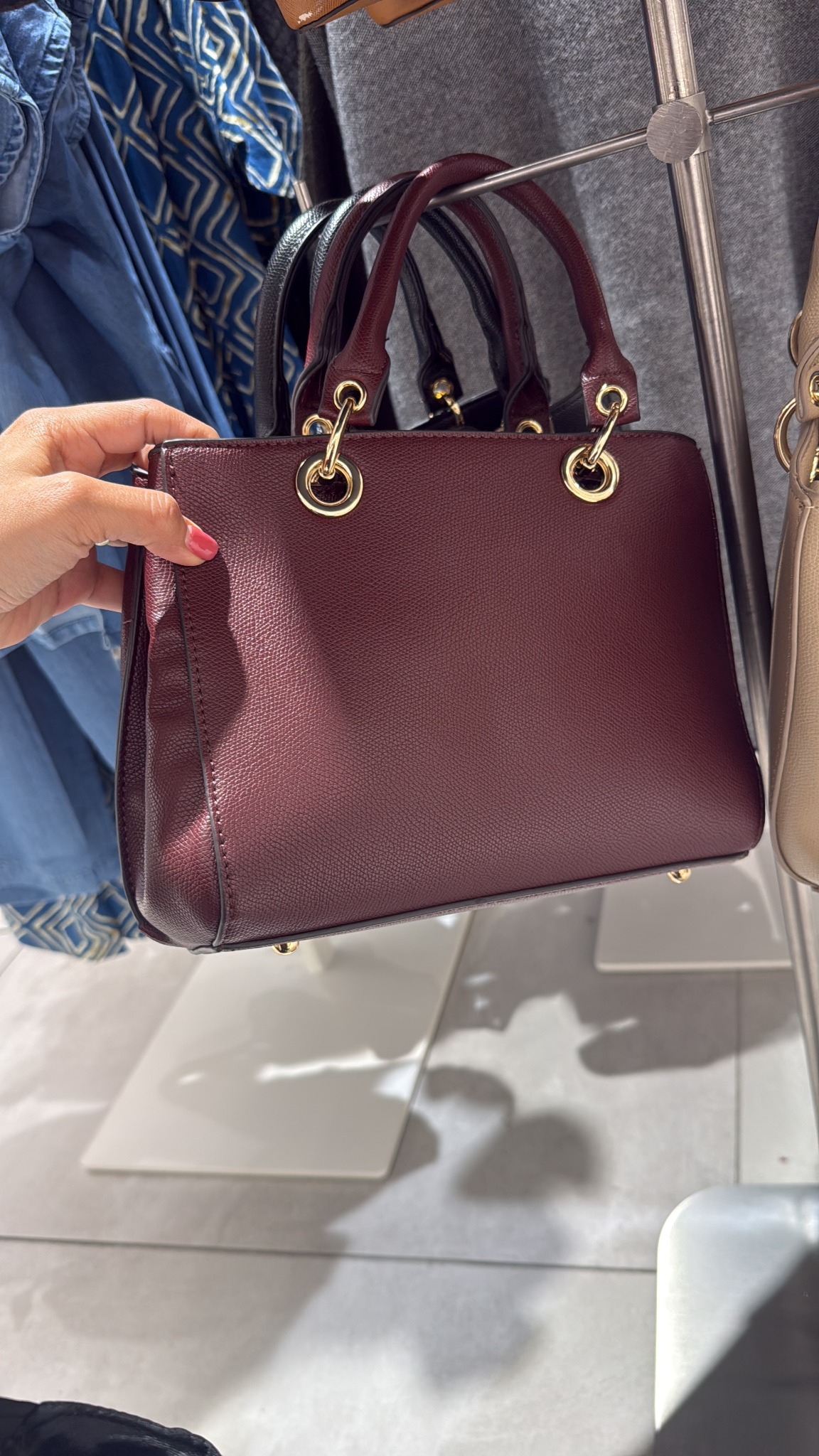 Bolso color vino con herrajes dorados seleccionado en tienda