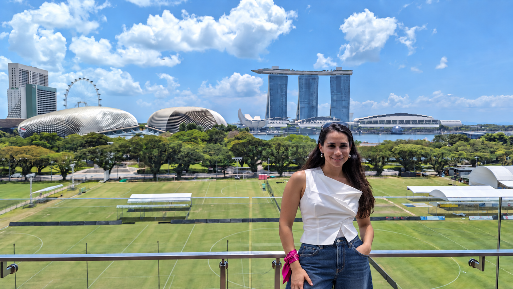 Vale Calvo en Singapur, con jeans índigo, top blanco y un pañuelo fucsia
